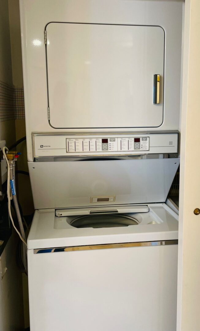 2225belleville12 | Apartments Homes Suites for Rent Victoria BC Stacked front loading washer and dryer unit in a laundry closet Maytag control panel visible beneath the dryer door