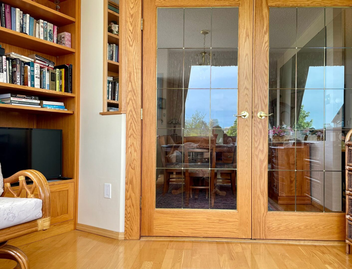 2225belleville4 | Apartments Homes Suites for Rent Victoria BC Wooden built in shelves full of books on the left with glass paneled French doors leading to a dining room