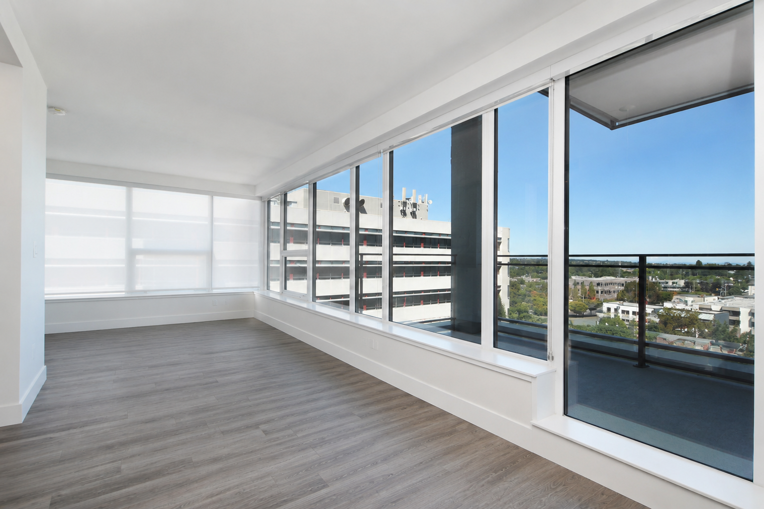 1106livingspace02 | Apartments Homes Suites for Rent Victoria BC Empty modern living area with large floor to ceiling windows and a balcony overlooking the city Informative