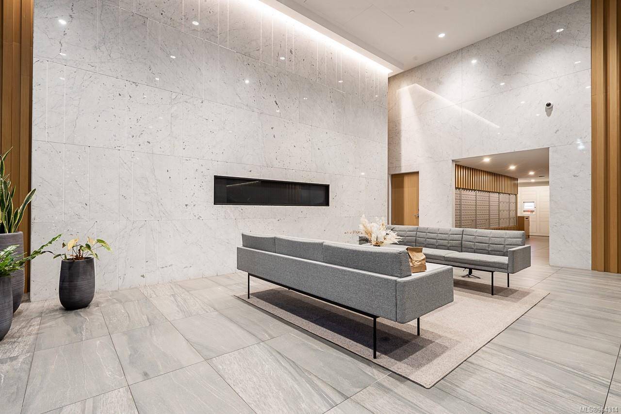 777lobby2 | Apartments Homes Suites for Rent Victoria BC Modern lobby with white marble walls gray sectional sofas and potted plants in a minimalist waiting area