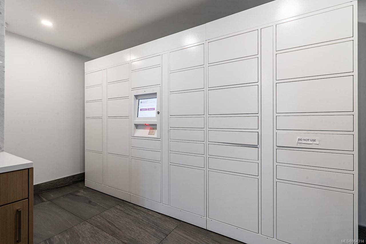 777lockers | Apartments Homes Suites for Rent Victoria BC Row of tall white parcel lockers with a central self service kiosk in a clean hallway one locker panel on the right reads DO NOT USE